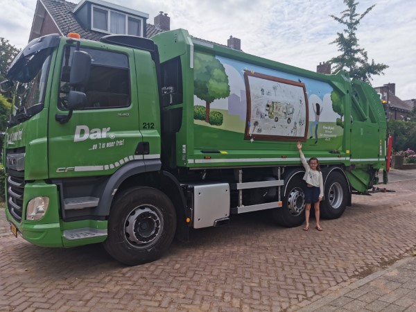 20240228 Winnaar Elma van de tekenwedstrijd 2023 bij de inzamelwagen met tekening erop Aangepast